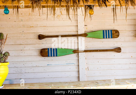 Canoa pagaie appesi al muro. Pagaie in legno parete bianca. Foto Stock