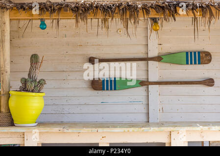 Canoa pagaie appesi al muro. Pagaie in legno parete bianca. Foto Stock