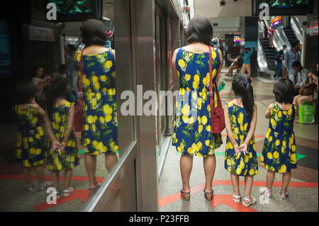 Singapore, Singapore, madre in attesa con le sue figlie in metropolitana Foto Stock