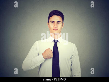 Closeup ritratto di fiducioso Uomo in camicia bianca isolata su sfondo grigio Foto Stock