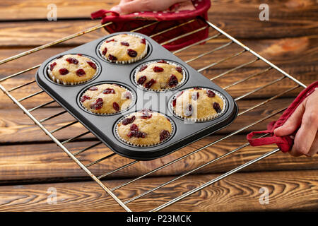 Muffin fatti in casa con la ciliegia in una forma di cottura sul broun sfondo di legno Foto Stock