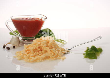 Formaggio grattugiato accanto ad alcuni tomatoe incolla Foto Stock