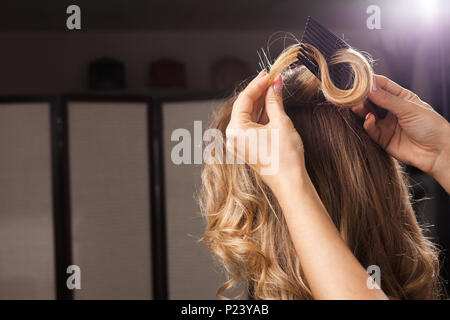 Parrucchiere pettinatura un arricciamento dei capelli Foto Stock