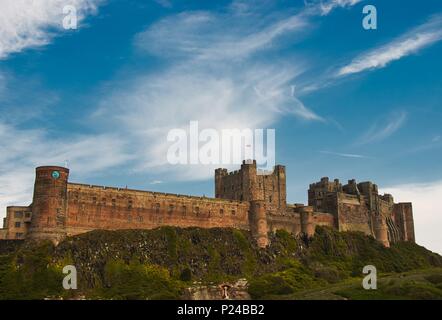 Sole che splende sulla imponente castello di Bamburgh, Northumberland Coast, Inghilterra Foto Stock