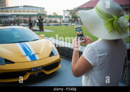 Singapore, Singapore, donna fotografato un giallo Ferrari Foto Stock