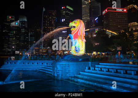 Singapore, Singapore, Merlion figura e il centro finanziario di notte Foto Stock