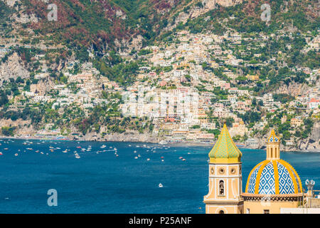 Praiano, Costiera Amalfitana, Salerno, Campania, Italia. La chiesa di Praiano con il villaggio di Positano in background Foto Stock