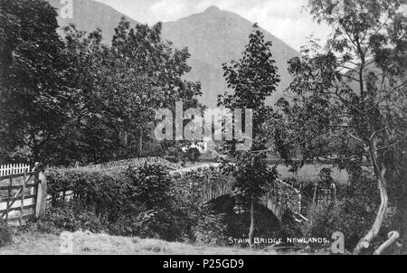 . Questa è la foto di un edificio elencato numero 1144574. Inglese: Guardando verso sud-ovest per il Grade II Listed dei primi del XIX secolo ponte Newlands Beck a scaletta in Newlands Valley, Cumbria, Inghilterra. La distanza è di 2.090 m. Causey Pike bordatura di Newlands Valley. Il fotografo è stato Henry Mayson, che era nato a Keswick e che ha impostato un studio fotografico vi nel 1880, la produzione di cartoline illustrate sotto il 'Mayson Series'. Il suo lavoro ha riguardato il paesaggio e le persone del distretto del lago. Il geog-posizione è la posizione approssimativa della fotocamera. prima del 1921. Henry Mayson (1845-1921) b Foto Stock