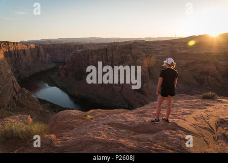 Una donna che si affaccia sul fiume Colorado in Pagina, Arizona durante il tramonto. Foto Stock