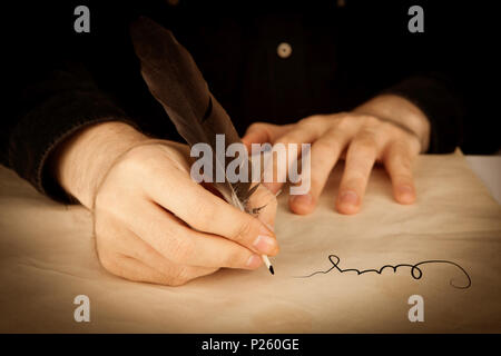 Una mano d'uomo tiene la penna stilografica e la firma di un contratto in primo piano Foto Stock