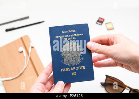 Passaporto brasiliano con accessori da viaggio in background Foto Stock