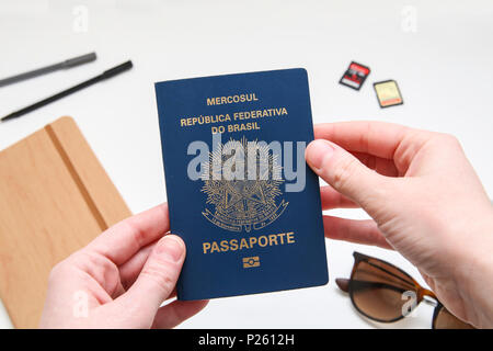 Passaporto brasiliano con accessori da viaggio in background Foto Stock