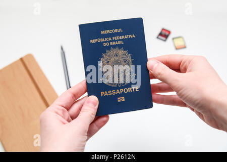 Passaporto brasiliano con accessori da viaggio in background Foto Stock