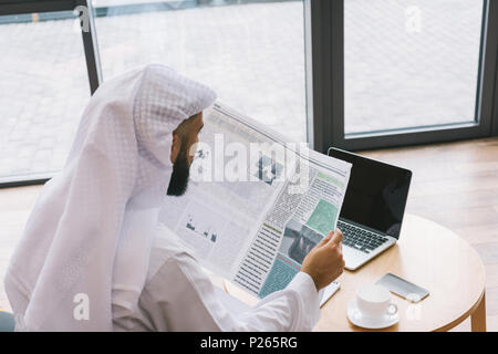 Imprenditore musulmano leggendo il giornale in ufficio moderno Foto Stock