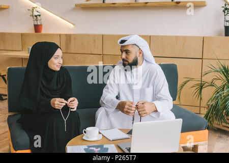 Musulmani partner business seduta sul lettino nella lobby di office Foto Stock