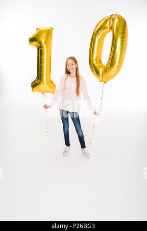 Adorabile femmina felice bambino azienda golden palloncini con numero dieci per il compleanno, isolato su bianco Foto Stock