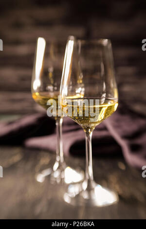 Ancora in vita con due pieni calici da bianco di fronte a sfondo grigio scuro Foto Stock