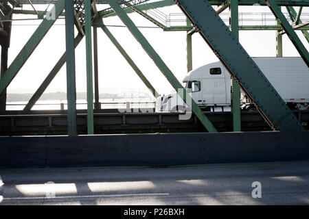 Profilo di white big rig long haul semi carrello con full size refrigerati semi rimorchio in esecuzione su arcuata di Interstate Columbia River ponte levatoio wit Foto Stock