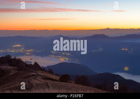 Vista del lago d'Orta, l'Isola di San Giulio e Monviso dalla sommità del Mottarone. Stresa, Verbano Cusio Ossola, Piemonte, Italia. Foto Stock