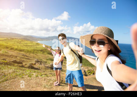 La famiglia felice tenendo selfie sulla costa Foto Stock