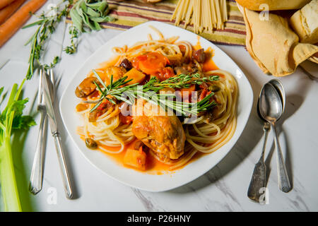 Pollo italiano Cacciatore il cacciatore stufato con spaghetti tagliatelle e crosta di pane Foto Stock