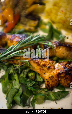 Grigliata di fresco greco spiedini di pollo con giallo riso allo zafferano Foto Stock