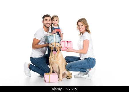 La famiglia felice e cane con presenta, isolato su bianco Foto Stock