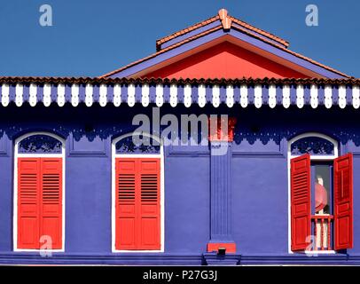 Vista frontale del patrimonio colorati Singapore shop house con esterni di colore blu, rosso antico persiane a lamelle e finestre ad arco nella storica Little India Foto Stock
