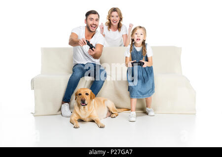 Famiglia eccitato la riproduzione del video gioco con joystick mentre dog sitter vicino, isolato su bianco Foto Stock