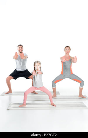 Famiglia di atletica a praticare yoga su stuoie insieme isolato su bianco Foto Stock