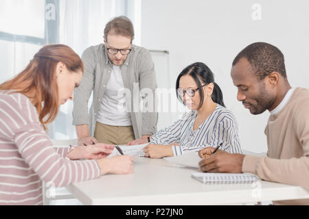 Multietnica medio di età compresa tra la gente di affari di lavorare con fogli insieme Foto Stock