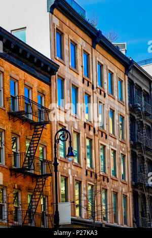 Manhattan, New York City, Soho, guardando il Tenement edifici di appartamenti, uno tradizionale con fuoco sfugge, uno aggiornato con finestre moderne. Foto Stock