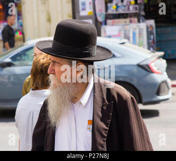 9 maggio 2018 un ebreo Chassidico invecchiato con una lunga barba bianca in abiti tradizionali a piedi in una strada trafficata a Gerusalemme, Israele Foto Stock