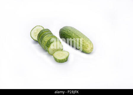 Cetrioli freschi, tutto il cetriolo affettato e isolato su bianco Foto Stock