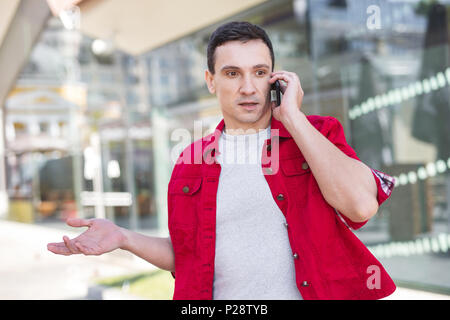 Dark-eyed man sensazione sorpresi dopo aver udito inaspettata novità Foto Stock