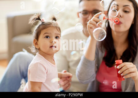 Famiglia con bolle di sapone a giocare a casa Foto Stock