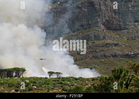 Un elicottero acqua-il bombardamento di un incendio sui pendii della Table Mountain e Cape Town , Sud Africa. Foto Stock