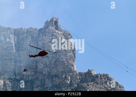 Un elicottero acqua-il bombardamento di un incendio sui pendii della Table Mountain e Cape Town , Sud Africa. Foto Stock