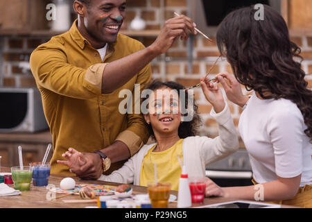 African American genitori e figlia divertirsi mentre la pittura delle uova di pasqua Foto Stock
