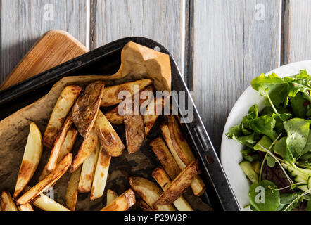 In casa la pelle al forno con patate fritte su un rustico sfondo di legno Foto Stock