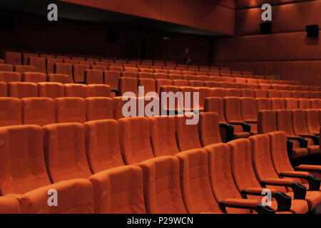 Velluto rosso posti nella fila e le pareti di un cinema o teatro / Theatre fase. Interno, colpo angolato. Foto Stock