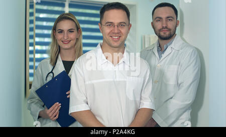 Sorridente giovani lavoratori medici in posa per la fotocamera Foto Stock