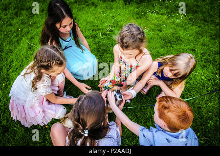 Un gruppo di bambini di accarezzare un cane Foto Stock