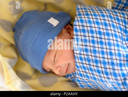 Carino Eurasian neonato sorridente nel suo sonno Foto Stock