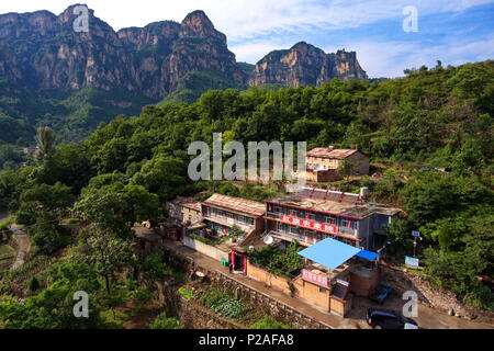 Taiyuan. 12 Giugno, 2018. Foto aerea adottate il 12 giugno 2018 mostra gli edifici per agriturismo in Shenlongwan villaggio in Changzhi, città del nord della Cina nella provincia dello Shanxi. Un 1,526-metro-lunga strada fu costruita lungo le scogliere per collegare Shenlongwan isolata all'esterno. La costruzione di questa strada miracolosa durò per quindici anni dal 1985 al 2000, e fu costruito a puro gli abitanti di un villaggio di Shenlongwan. Grazie a questa strada, gli abitanti di un villaggio qui ora cast off la povertà mediante lo sviluppo del turismo. Credito: Cao Yang/Xinhua/Alamy Live News Foto Stock