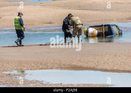 Appledore, North Devon, Regno Unito. Xiv Jun, 2018. Con la bassa marea Royal Marines in base a Instow aiutare la comunità locale mediante il recupero di un veicolo 4x4 che è incagliata nel fiume Torridge estuary oltre una settimana fa. Grandi folle sono state disegnate in banchina a Appledore ed acclamato come il veicolo è stata trasportata a terra questo pomeriggio. Credito: Terry Mathews/Alamy Live News Foto Stock