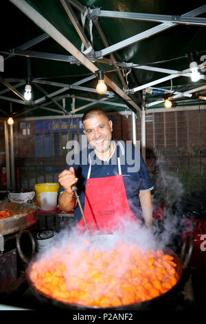 Manchester, Regno Unito. 14 giugno 2018. Un uomo di cottura a celebrazioni di Chaand Raat, che tradotto significa letteralmente la Notte della luna. Il festival segna la fine del mese di Ramadan e la notte prima di Eid. Mercato Longsight, Manchester, 14 giugno 2018 (C)Barbara Cook/Alamy Live News Foto Stock