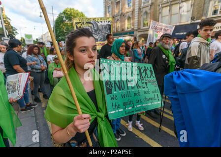 Londra, Regno Unito. 14 giugno 2018. Una donna che tiene un poster 'Nessuna giustizia nessuna pace' come lei cammina con migliaia in silenzio lungo la Ladbroke Grove ricordando le vittime del disastro nel primo anniversario del disastroso incendio che ha ucciso 72 e lasciato superstiti traumatizzati. Molte di quelle rese senzatetto dal fuoco sono ancora in un alloggio temporaneo di un anno più tardi, nonostante le promesse mde di Theresa Maggio e a Kensington & Chelsea consiglio che molti caddero hanno fallito la comunità locale sia prima e dopo l'incendio. Chiamata per Credito: Peter Marshall / Alamy Live News Foto Stock