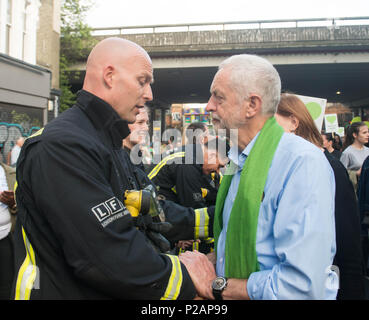 Londra, Inghilterra. 14 giugno 2018. Il leader del partito laburista, Jeremy Corbyn saluta i vigili del fuoco durante una marcia silenziosa in un anno anniversario della torre Grenfell fire. In silenzio a piedi è tenuto in occasione del primo anniversario della torre Grenfell fire, che è costato la vita di 72 persone. ©Michael Tubi/Alamy Live News Foto Stock