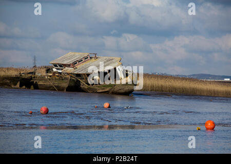 Una casa galleggiante abbandonati e un paio di chiatte marciume sulle velme del Fiume Exe a Topsham, Devon, Inghilterra, Regno Unito Foto Stock